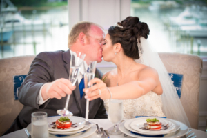 NJ Wedding Photographer - Ariana and Andy's Wedding at Crystal Point Yacht Club Newlyweds kissing and toasting champagne at Crystal Point Yacht Club