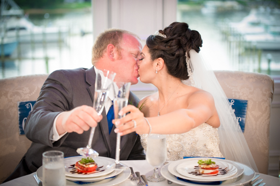 NJ Wedding Photographer - Ariana and Andy's Wedding at Crystal Point Yacht Club Newlyweds kissing and toasting champagne at Crystal Point Yacht Club