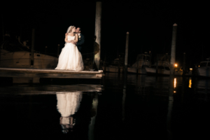 NJ Wedding Photographer - Cheryl and Jose's Wedding at Crystal Point Yacht Club Newlyweds kissing infront of water at night