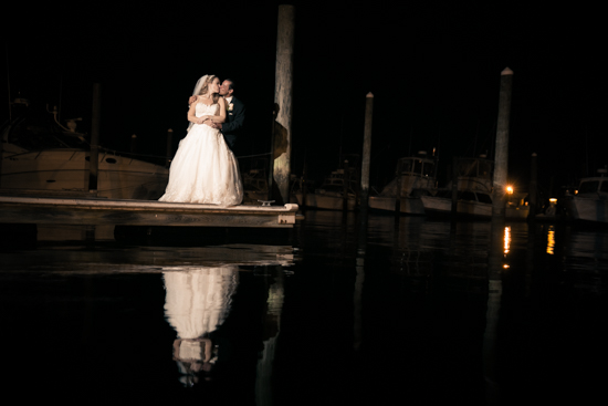 NJ Wedding Photographer - Cheryl and Jose's Wedding at Crystal Point Yacht Club Newlyweds kissing infront of water at night
