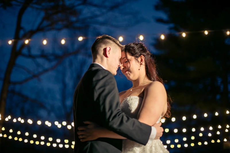 Newlyweds under the string lights at The Pavilion on Crystal Lake wedding photos